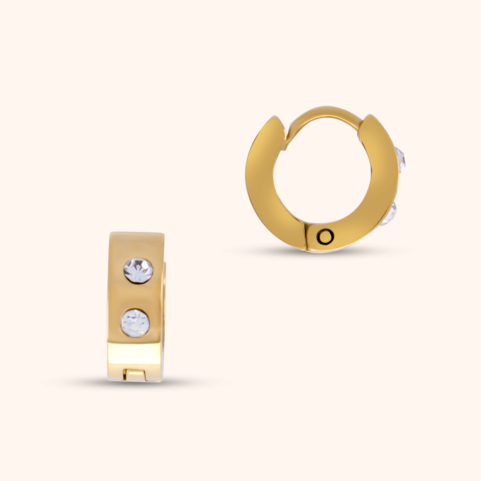 Close-up of a single PRESSIE Aperture Hoop earring; a 14k gold-plated hinged hoop earring with two small, clear, round stones set on the front.